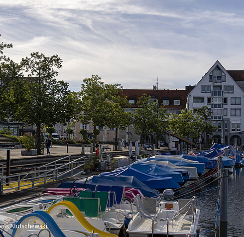 Bunte Boote im kleinen Hafen von Friedrichshafen am Bodensee Mehrere bunte Boote liegen im kleinen Hafen von Friedrichshafen am Bodensee.