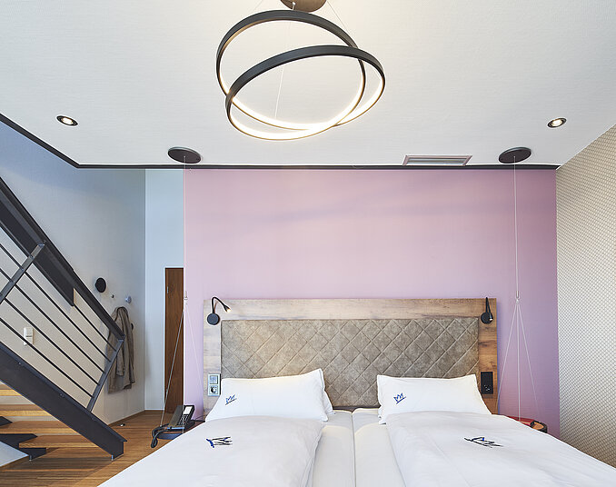 Doppelzimmer mit modernem Design und stilvollem Bett – gemütliche Hotelzimmer am Bodensee buchen.
