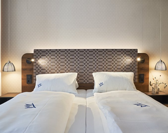 Modernes Doppelbett in einem stilvollen Zimmer im 4 Sterne Hotel in Friedrichshafen.