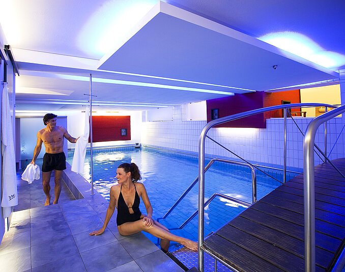 Moderner Wellnessbereich mit beleuchtetem Innenpool, entspannter Atmosphäre im Tagungshotel Friedrichshafen.