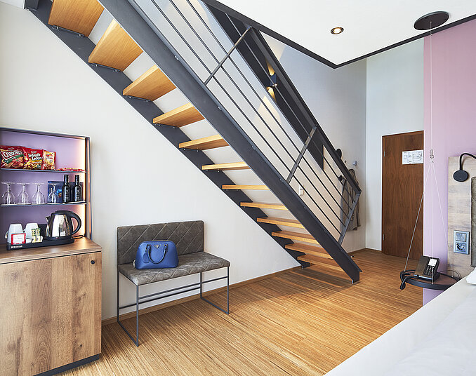Modernes Maisonette-Zimmer mit Treppe und Minibar – stilvolle Hotelzimmer am Bodensee entdecken.
