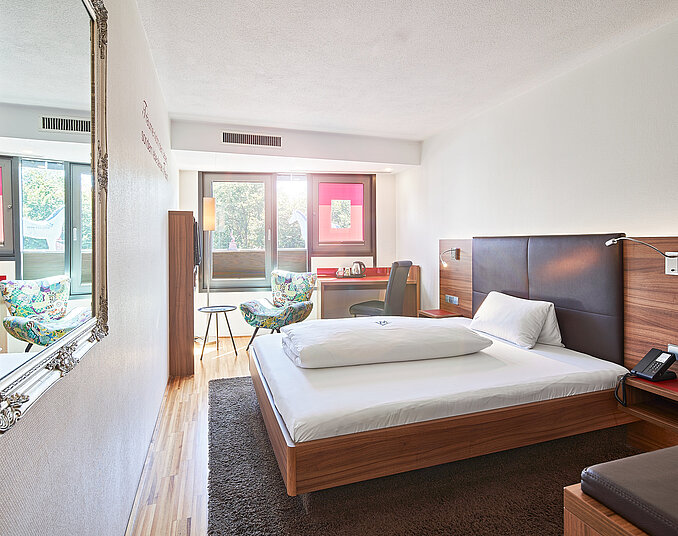 Helles Einzelzimmer mit Schreibtisch und Balkon – komfortable Hotelzimmer am Bodensee genießen.