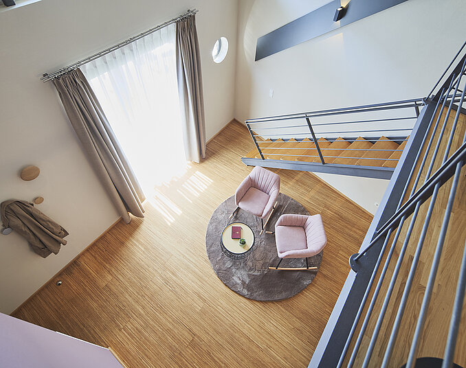 Maisonette-Hotelzimmer mit hoher Decke und Sitzecke – stilvolle Hotelzimmer am Bodensee genießen.