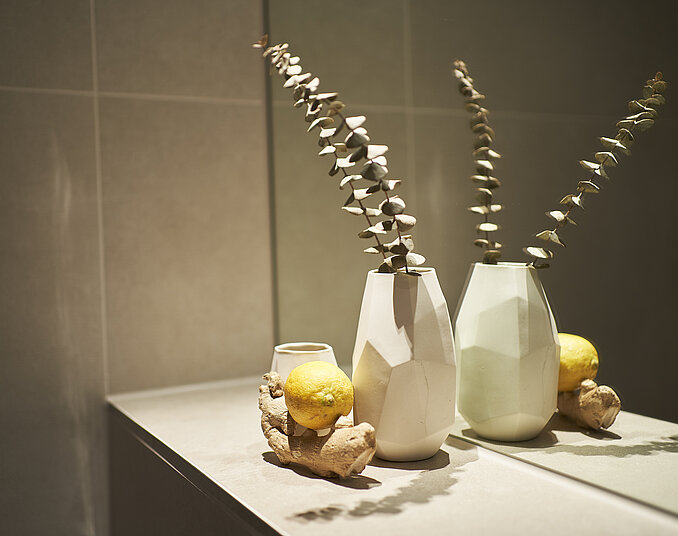 Stilvolle Deko mit Vase, Zitrone und Ingwer – liebevolle Details in Hotelzimmern am Bodensee.