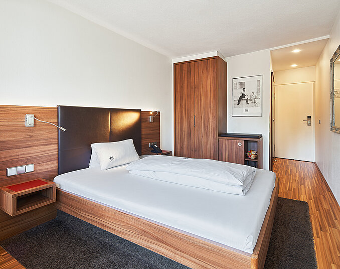 Gemütliches Einzelzimmer mit Holzmöbeln und Minibar – stilvolle Hotelzimmer am Bodensee buchen.