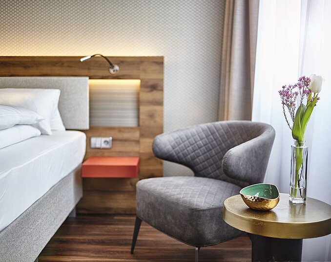 Modernes Doppelzimmer mit Sitzecke mit Sessel und Tisch