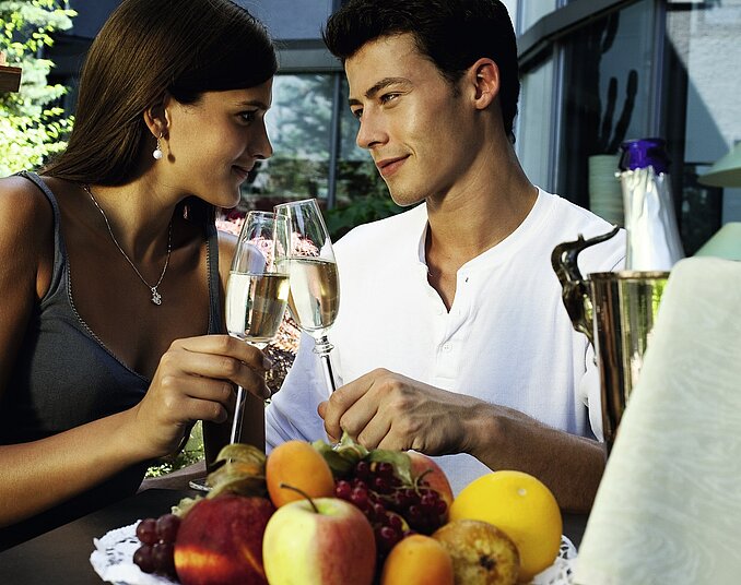 Romantischer Moment zu zweit mit Sekt und frischem Obst bei stilvollem Ambiente.