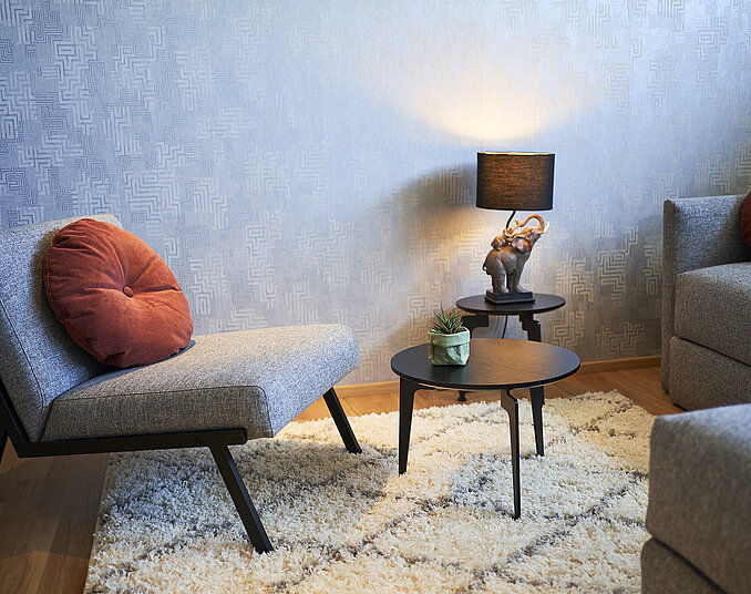Gemütliche Sitzecke mit Lampe und Teppich – stilvoll eingerichtete Hotelzimmer am Bodensee.