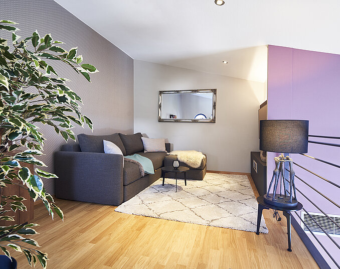 Gemütliche Sitzecke mit Sofa und Teppich in modernem Hotelzimmer am Bodensee.