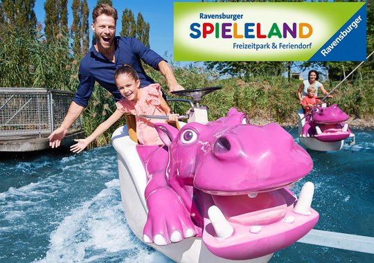 Eine lächelnde Frau und ein Kind fahren auf einem pinken Wasserfahrzeug in Form eines Nilpferds durch einen Freizeitpark. Im Hintergrund ist ein weiteres Fahrzeug zu sehen. Oben links befindet sich das Logo des Ravensburger Spielalands.