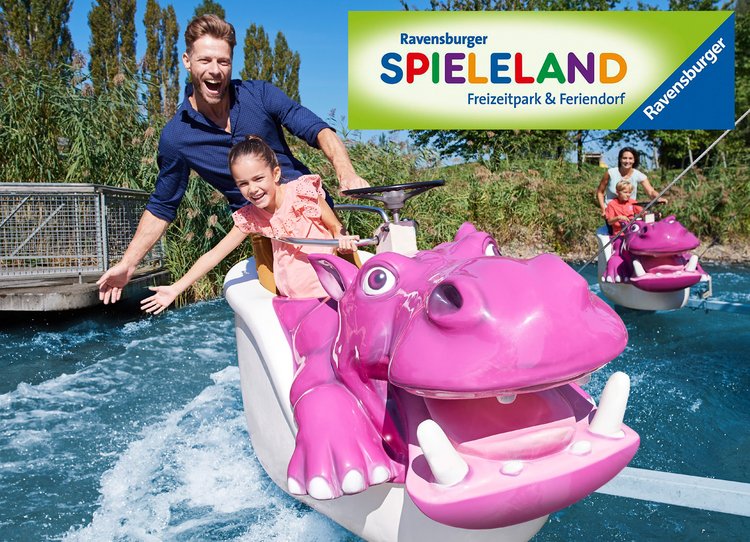 Das Nilpferd in der Wasserbahn Eine lächelnde Frau und ein Kind fahren auf einem pinken Wasserfahrzeug in Form eines Nilpferds durch einen Freizeitpark. Im Hintergrund ist ein weiteres Fahrzeug zu sehen. Oben links befindet sich das Logo des Ravensburger Spielalands.